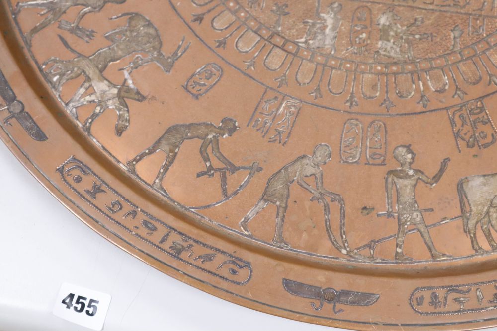 A large circular copper tray with white metal inlay depicting ancient Egyptian scenes, diameter 61cm